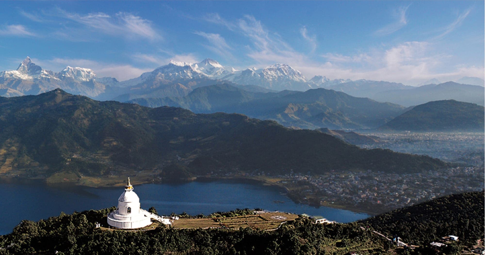 Aerial view of the World Peace Stupa above Phewa Lake with the Annapurna range behind