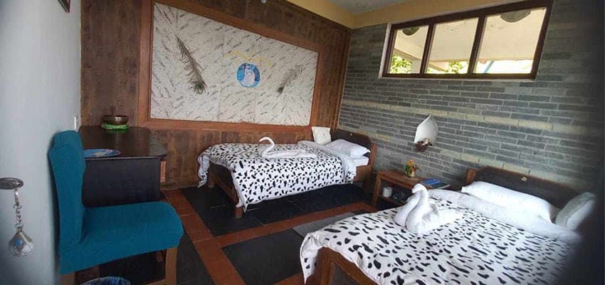 A twin room with painted wall art and turned-down beds