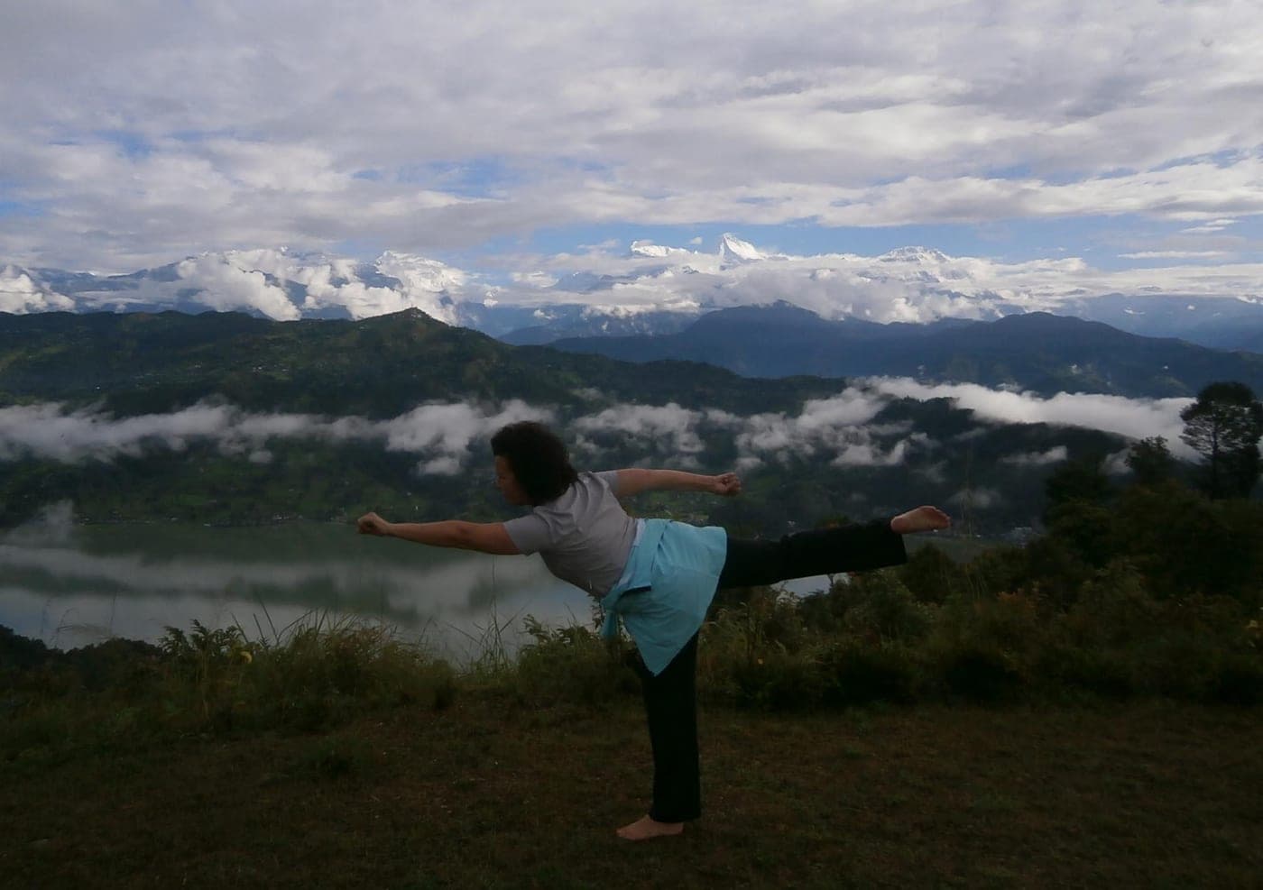 A guest practising yoga on the ridge as cloud fills the valley below